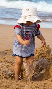 infant playing on beach in puddle photo